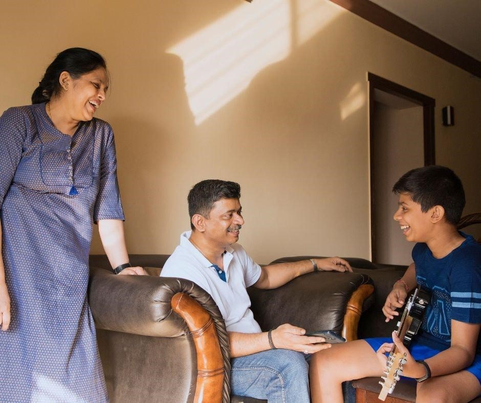 a boy playing guiter infront of his parents